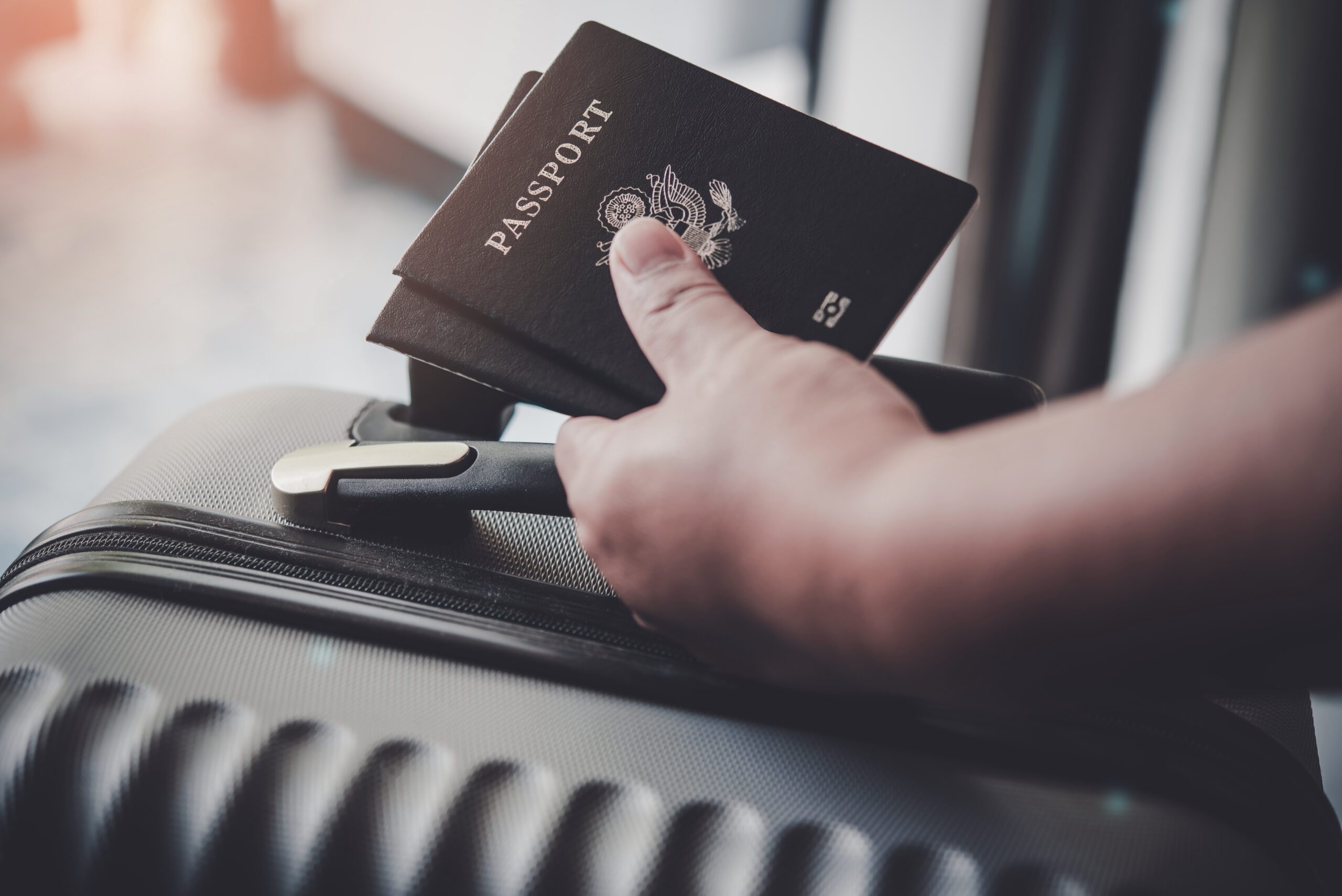 A hand holding a passport on top of a suitcase, symbolizing a digital product passport for tracking and authenticity.